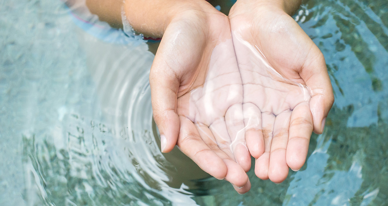 Hände, die in Wasser getaucht sind
