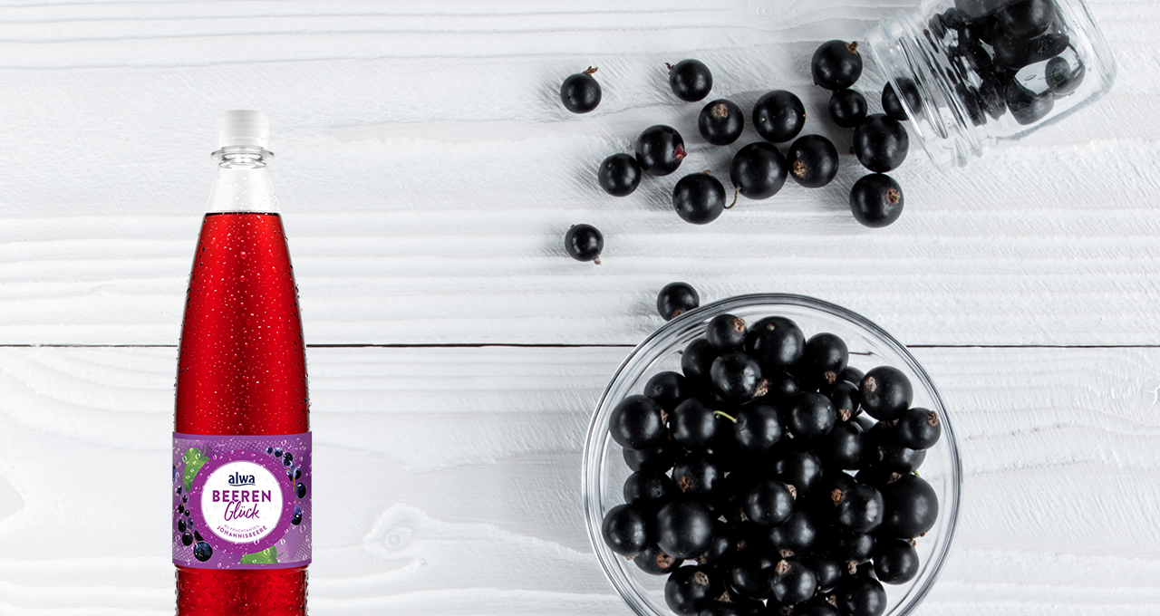 alwa Johannisbeerschorle und Johannisbeeren in einer Glasschüssel